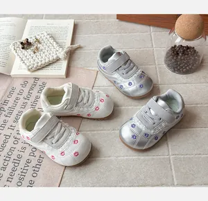 Vista dettagliata di sneaker stile ballerina per bambine con ricami floreali e pizzo