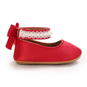 Detaillierte Seitenansicht roter Satin-Babyschuh für Mädchen mit Perlenband und Schleife