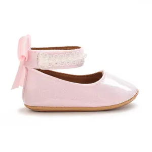 Gros plan de chaussures de marche pailletées roses pour bébés filles avec perles et nœud