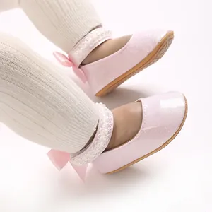 Gros plan de chaussures roses pailletées pour bébé fille avec perles et nœuds élégants