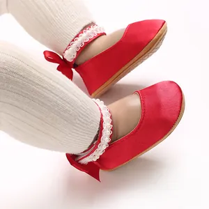 Detaillierte Nahaufnahme roter Baby Prinzessinenschuhe mit Perlen-Spitzenriemen und Schleife