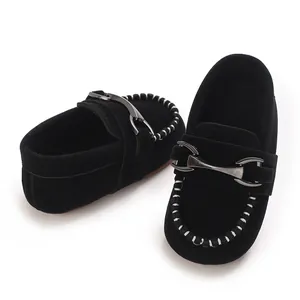 Detail shot of black faux suede baby loafers with metal buckle and contrast stitching