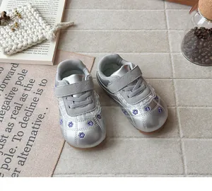 Vista dettagliata di sneaker stile ballerina argento per bambine con ricami floreali e pizzo.
