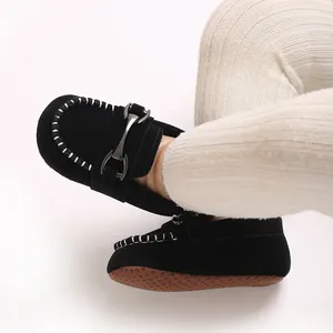 Close-up of black suede baby loafers with metal buckle and non-slip sole for infants.
