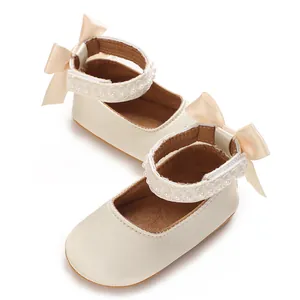 Detailansicht der cremefarbenen Baby-Prinzessinenschuhe mit Schleife und Perlen