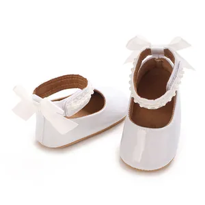 Détail de chaussures blanches pailletées pour bébé avec perles et nœud