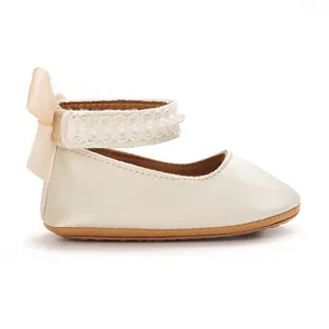 Seitenansicht cremefarbene Babyschuhe für Mädchen mit Perlen und Schleife