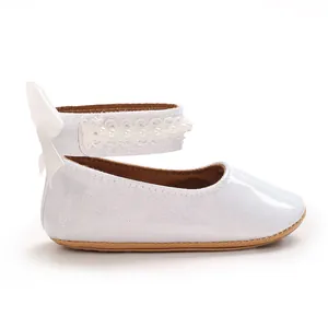 Vue détaillée de chaussures de marche blanches pailletées pour bébé avec perles et nœud.