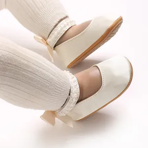 Detailansicht cremeweißer Babyschuhe für Mädchen mit Perlenriemen und Schleife am Absatz