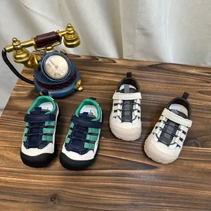 Deux paires de chaussures de sport respirantes pour enfants sur une surface en bois
