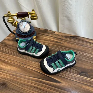 Vue détaillée de baskets en maille respirante pour enfants au design vert et bleu marine.