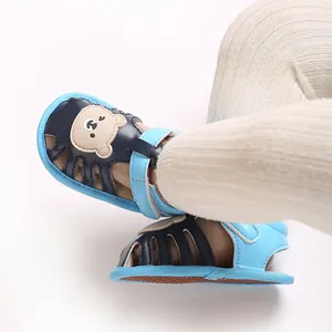 Detaillierte Ansicht der niedlichen Baby-Sandalen mit Bärenmotiv an den Füßen