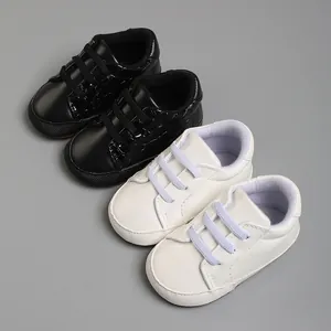 Chaussures de marche classiques noir et blanc pour bébé à semelle souple, 0-18 mois.