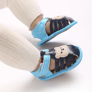 Nahaufnahme von niedlichen Baby-Sandalen mit Bären-Motiv und weicher Anti-Rutsch-Sohle