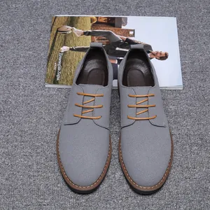 Vue détaillée de chaussures décontractées en daim gris pour hommes avec lacets orange contrastés