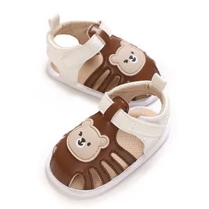 Nahaufnahme des niedlichen Braunbärenmusters auf weißen weichen Baby-Lauflern-Sandalen