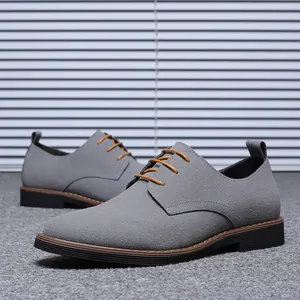 Vue détaillée de chaussures décontractées en daim gris pour hommes avec des lacets bruns