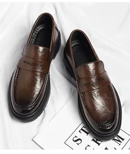 Detailansicht von dunkelbraunen Leder-Loafers mit dicken Sohlen auf weißem Stoff