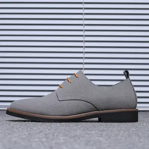 Profil latéral d'une chaussure derby décontractée pour homme en daim gris avec lacets oranges