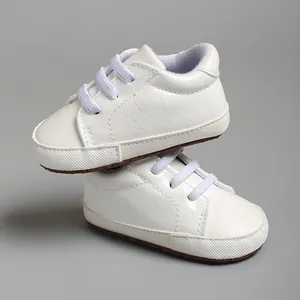 Vue détaillée de chaussures de marche blanches pour bébé avec texture crocodile.