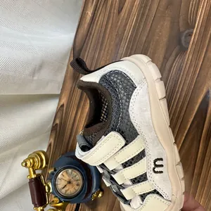 Gros plan de baskets en maille respirante pour enfants, détails en beige et gris.