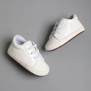Gros plan de baskets blanches pour bébé avec semelles souples et lacets élastiques violet clair
