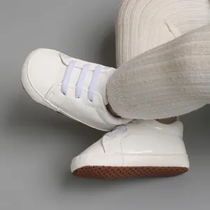 Vue détaillée de chaussures de marche blanches pour bébé avec semelles souples antidérapantes