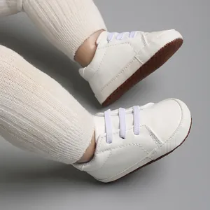 Vue détaillée de chaussures de marche pour bébé blanches avec texture en crocodile