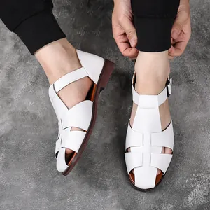 Close-up van stijlvolle witte heren Romeinse sandalen op een model met grijze achtergrond