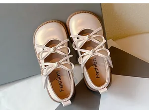 Vista detallada de zapatos de princesa para niñas con doble lazo en color beige