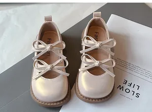 Vista detallada de zapatos Mary Jane beige para niña con elegante diseño de doble lazo