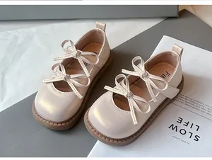 Primer plano de los zapatos de princesa para niñas en crema con doble lazo y suela suave
