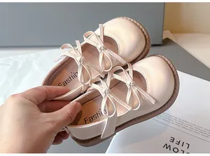 Detalle de zapatos Mary Jane beige para niña con elegantes lazos dobles suaves