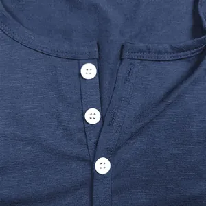 Primer plano detallado del cuello Henley azul con botones blancos y textura de algodón slub.