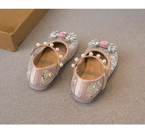 Close-up of pink girls' princess shoes featuring glittering sequins, rhinestones and pearls