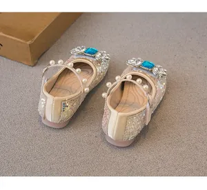 Detail view of girls' sparkling princess shoes with sequins and blue rhinestone bow