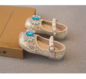 Detail of sparkly girls' princess flats with blue rhinestone and pearl strap detail.