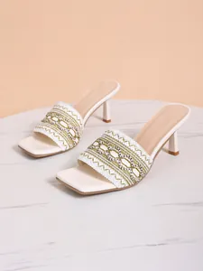 Detailed view of white bohemian high-heel sandals with elegant embroidered wide strap