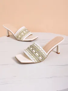 Detailed view of white bohemian embroidered heeled sandals with square toe design.