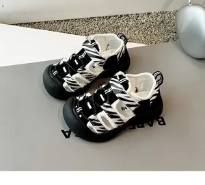 Primer plano de sandalias de cebra para niños con punta cerrada y diseño calado