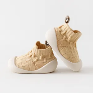 Beige knit baby floor shoes with soft soles for pre-walking infants.