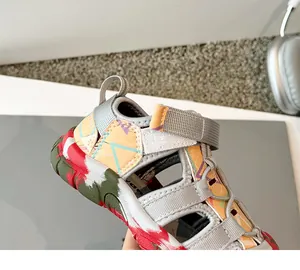 Detalle de sandalias cerradas para niños con estampado geométrico y cierre de velcro
