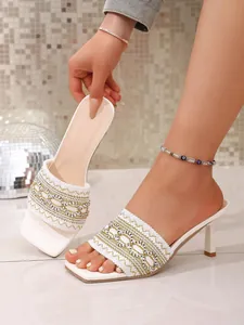 Detailed view of elegant white bohemian kitten heel mules with intricate woven strap