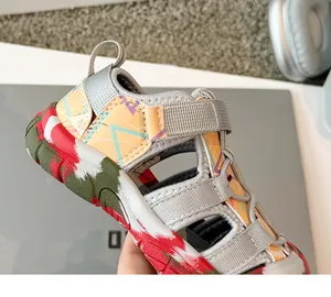 Detalle de sandalia calada para niño con patrones geométricos y cierre de velcro.