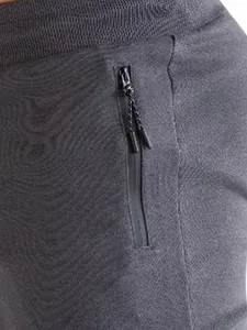 Dettaglio della tasca con cerniera impermeabile sui pantaloncini da corsa grigi.