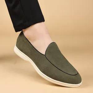 Close-up van olijfgroene suède loafers voor heren met stijlvolle zwarte biesjes