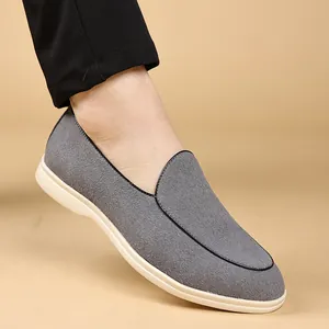 Detailopname van grijze suède herenloafers met een comfortabele witte zachte zool