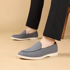 Close-up van grijze casual loafers voor heren met witte zachte zool en zwarte bies