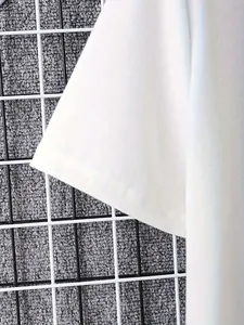 Vue détaillée de la manche d'un T-shirt blanc avec une finition à double couture soignée