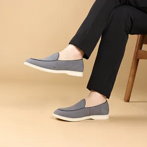 Zijaanzicht van comfortabele grijze herenloafers met zachte witte zolen en zwarte bies.
